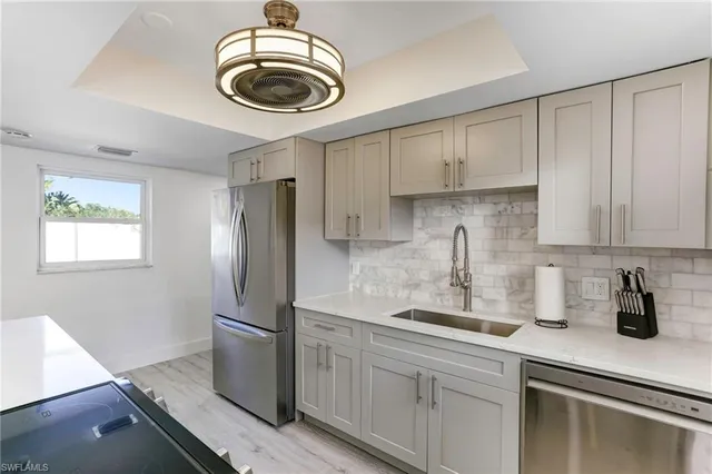 a kitchen with stainless steel appliances a sink a stove a refrigerator and cabinets