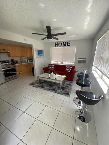 a living room with furniture and kitchen view