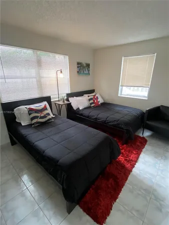 a bedroom with two bed and a window