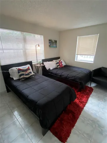 a bedroom with two bed and a window