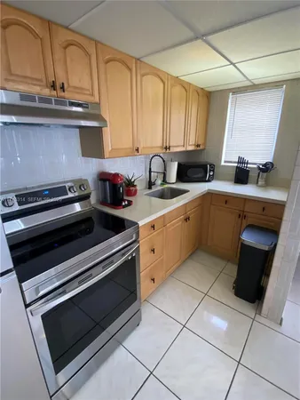 a kitchen with a stove sink and cabinets