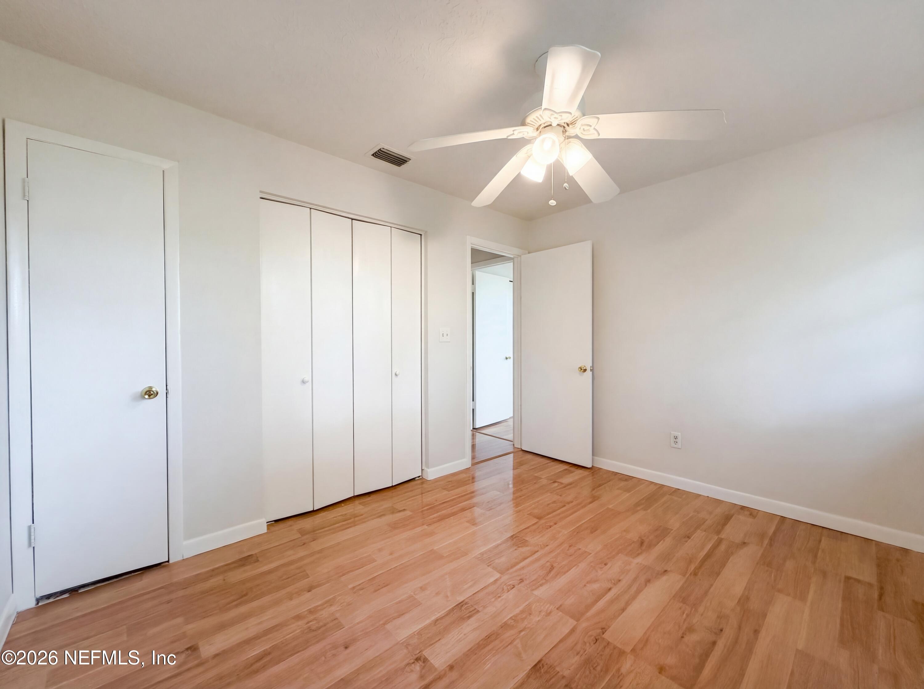 6917 Gatorbone Road Keystone Heights, FL 32656 - Photo 17 of 24 an empty room with wooden floor fan and windows