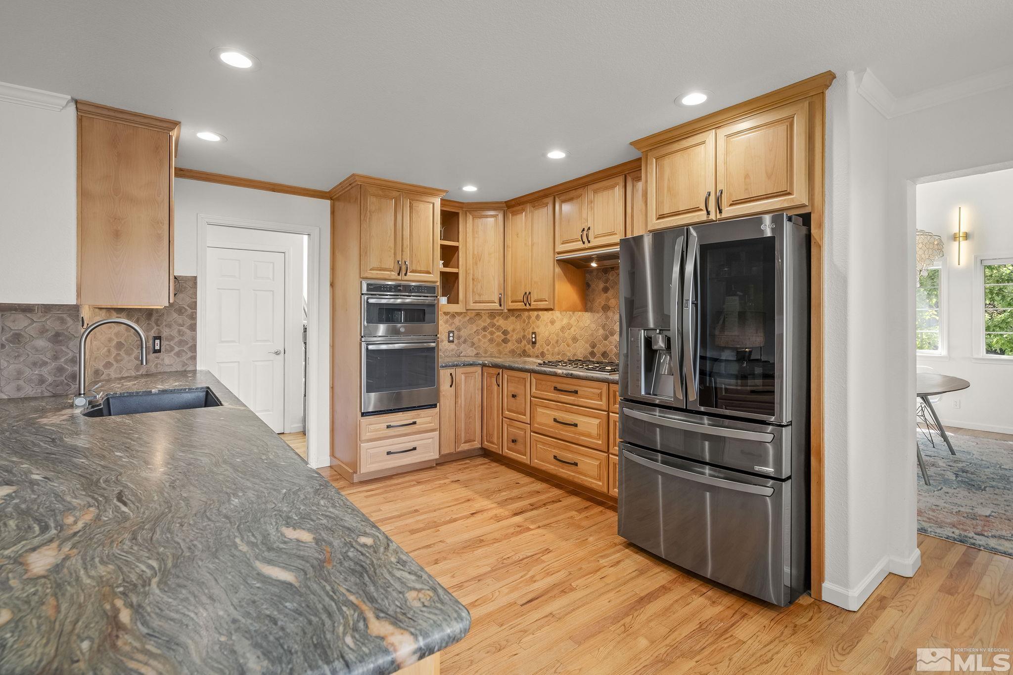 3341 Corey Drive Reno, NV 89509 - Photo 12 of 40 a kitchen with stainless steel appliances kitchen island granite countertop a refrigerator and a stove top oven