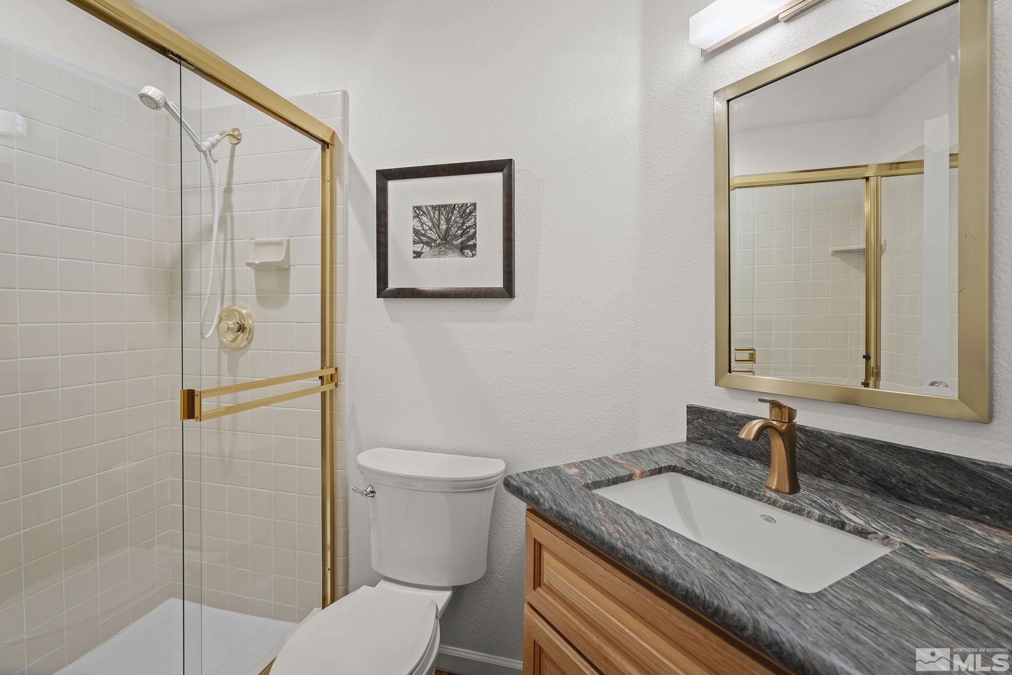 3341 Corey Drive Reno, NV 89509 - Photo 17 of 40 a bathroom with a granite countertop toilet sink and mirror
