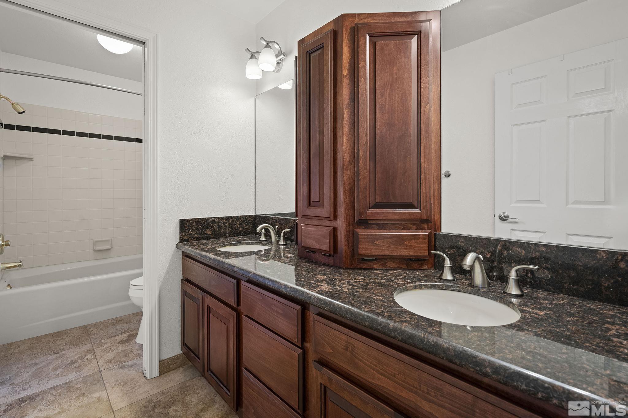 3341 Corey Drive Reno, NV 89509 - Photo 23 of 40 a bathroom with a granite countertop sink and a mirror