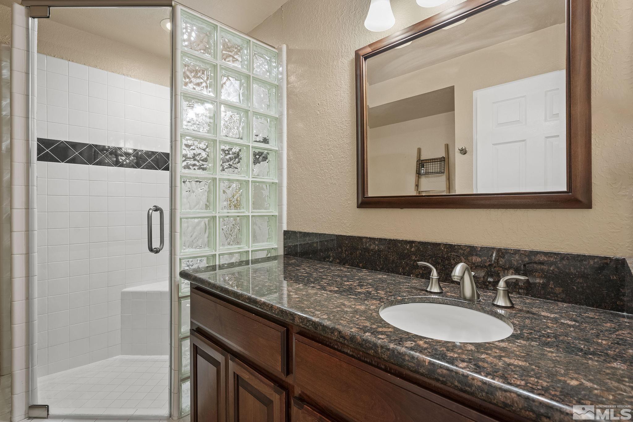 3341 Corey Drive Reno, NV 89509 - Photo 29 of 40 a bathroom with a granite countertop sink and a mirror