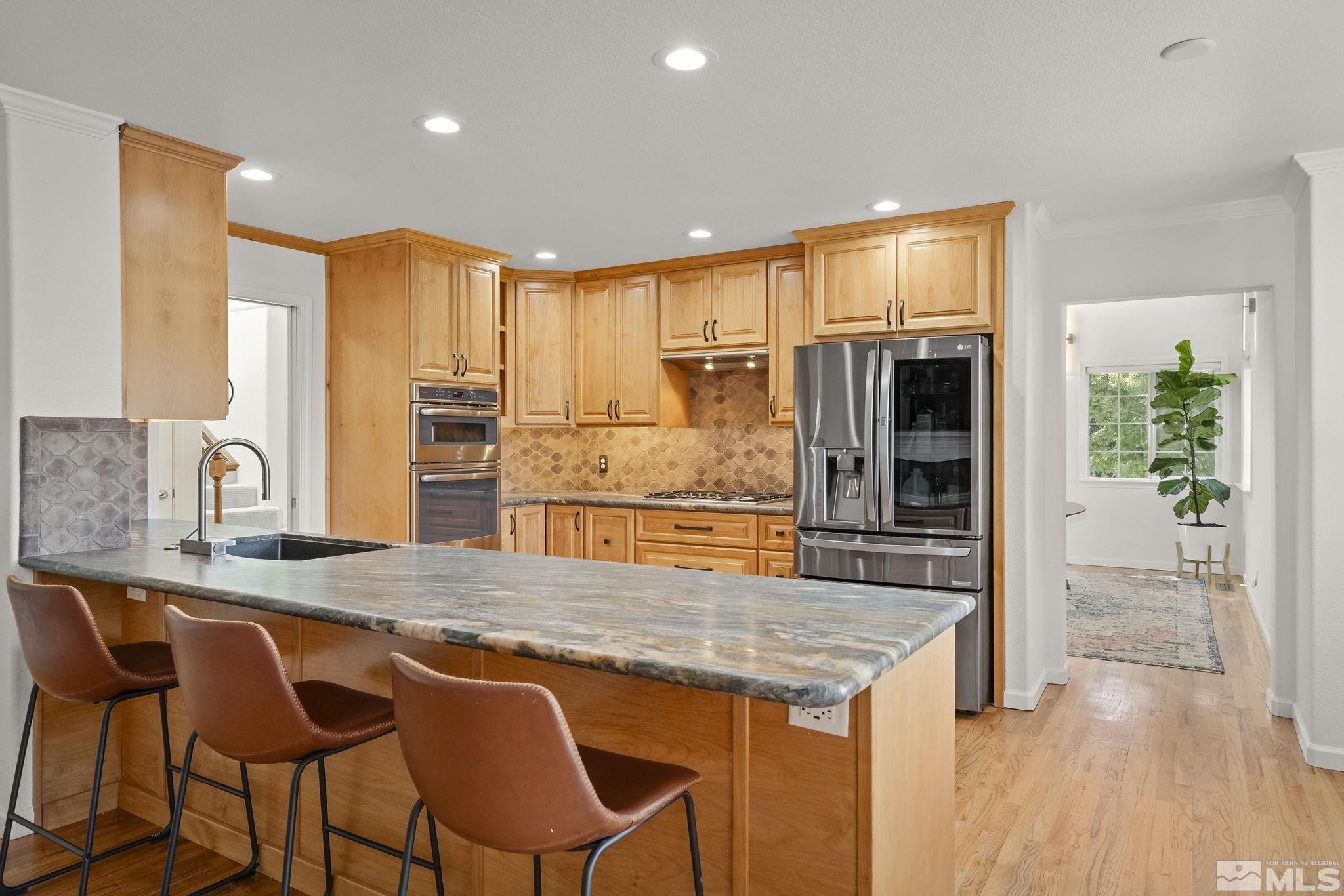 3341 Corey Drive Reno, NV 89509 - Photo 9 of 40 a kitchen with stainless steel appliances granite countertop a stove top oven a sink and cabinets