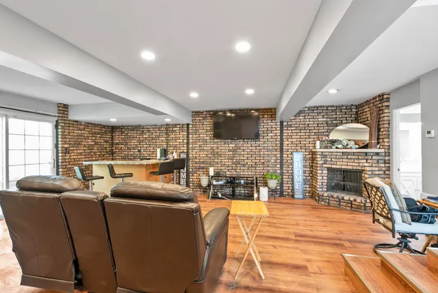 a living room with furniture a large window and a wooden floor