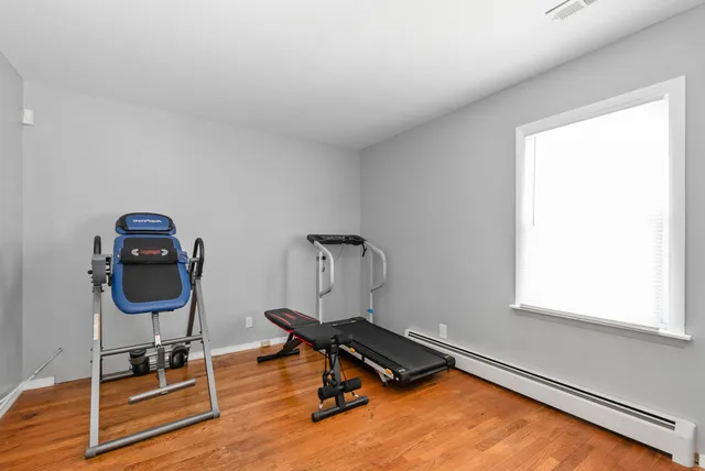 a room with gym equipment on wooden floor