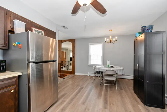 a kitchen with stainless steel appliances refrigerator dining table and chairs