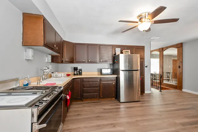 a kitchen with stainless steel appliances granite countertop a stove top oven a refrigerator a sink and dishwasher