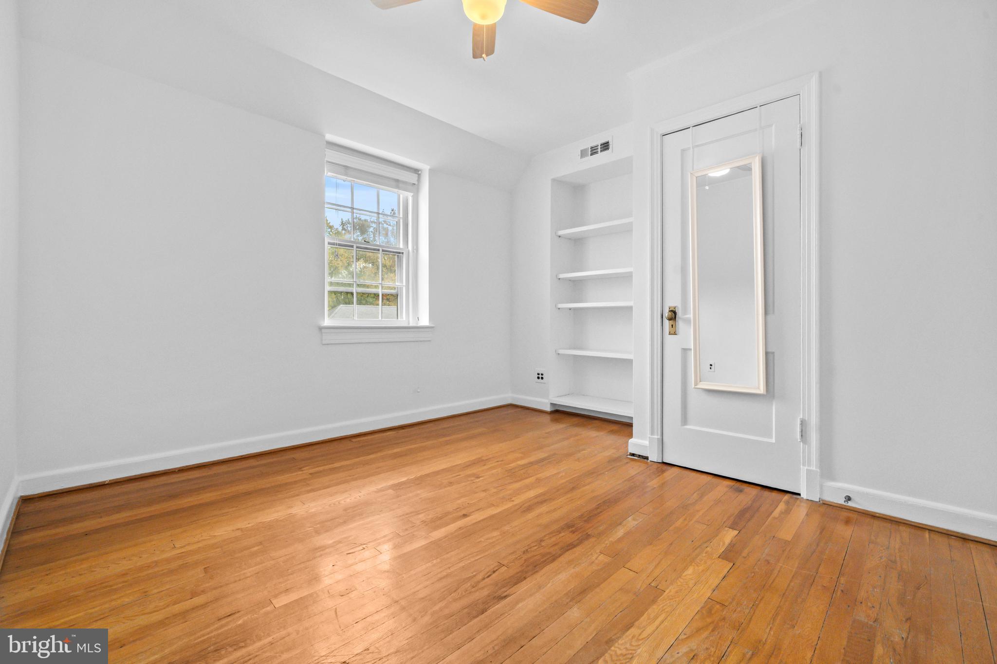 1400 South Edgewood Street, Unit 527 Arlington, VA 22204 - Photo 21 of 32 an empty room with wooden floor and windows