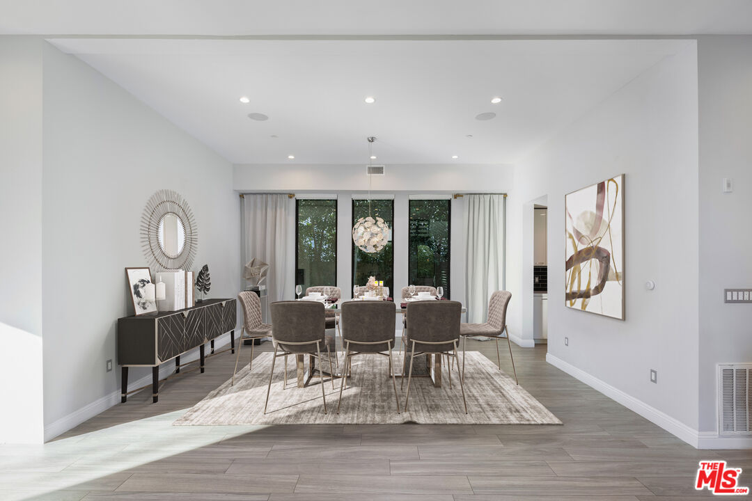 156 North Wetherly Drive Beverly Hills, CA 90211 - Photo 12 of 57 a dining room with wooden floor a rug a fireplace and a chandelier