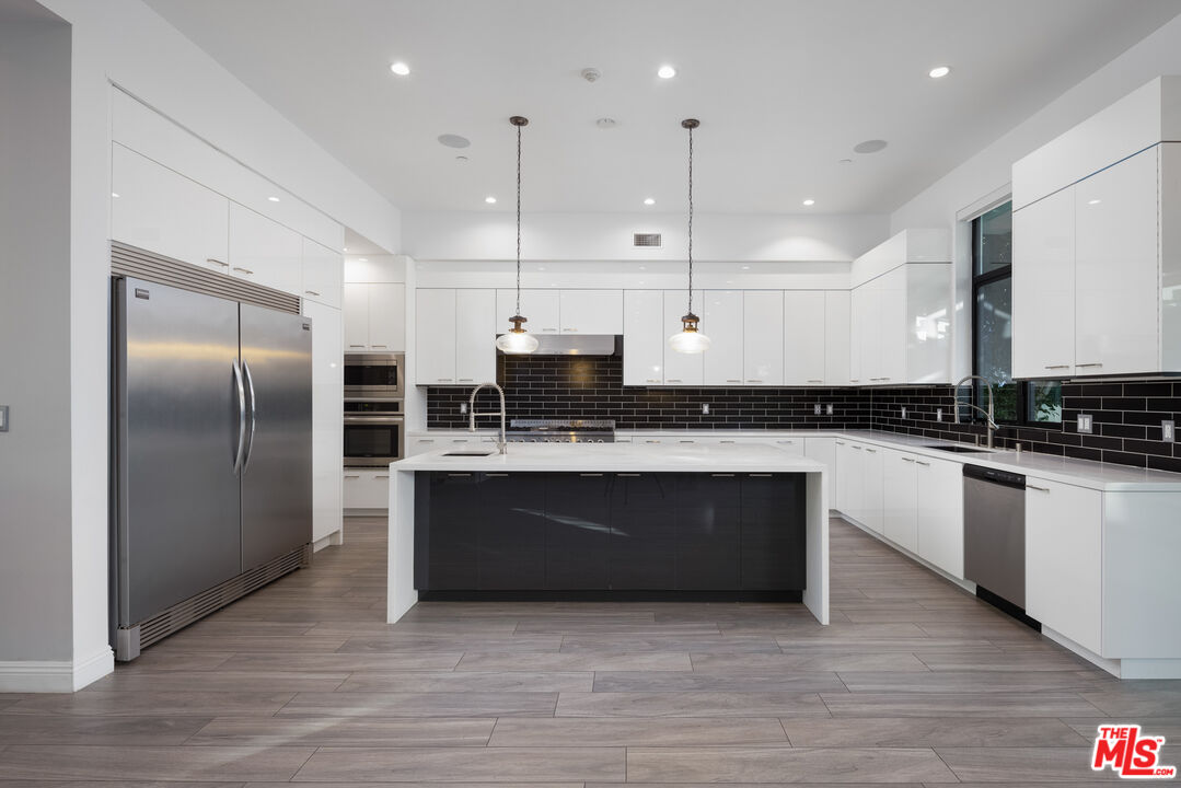 156 North Wetherly Drive Beverly Hills, CA 90211 - Photo 14 of 57 a large kitchen with stainless steel appliances granite countertop a stove a sink and a refrigerator