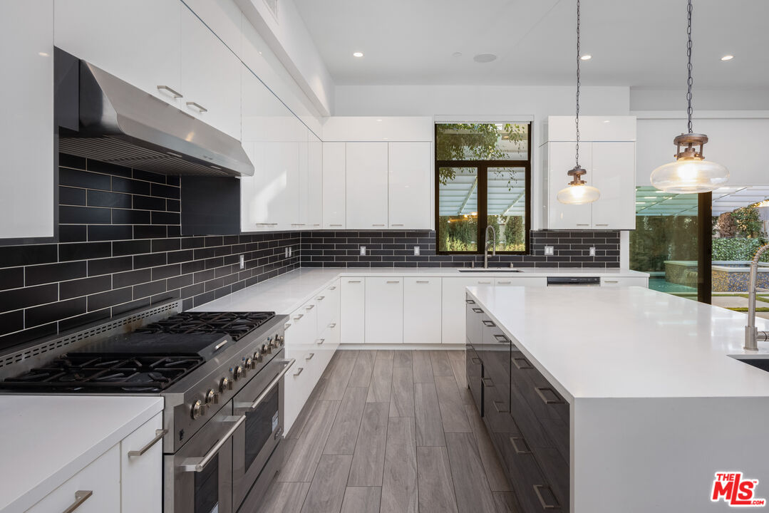 156 North Wetherly Drive Beverly Hills, CA 90211 - Photo 15 of 57 a kitchen with a sink a stove and cabinets