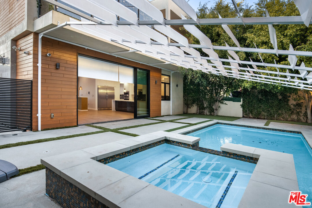 156 North Wetherly Drive Beverly Hills, CA 90211 - Photo 19 of 57 a view of a patio with table and chairs with wooden floor and plants