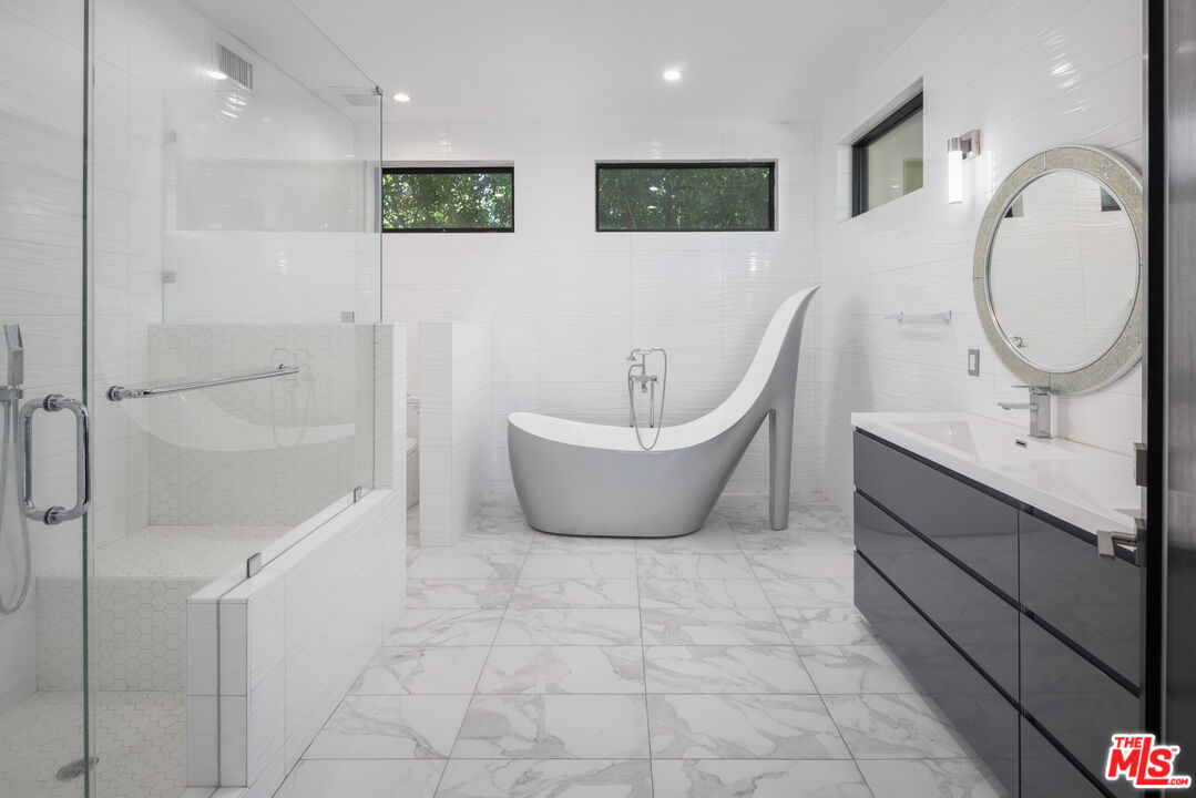 156 North Wetherly Drive Beverly Hills, CA 90211 - Photo 42 of 57 a spacious bathroom with a double vanity sink a mirror and a bathtub