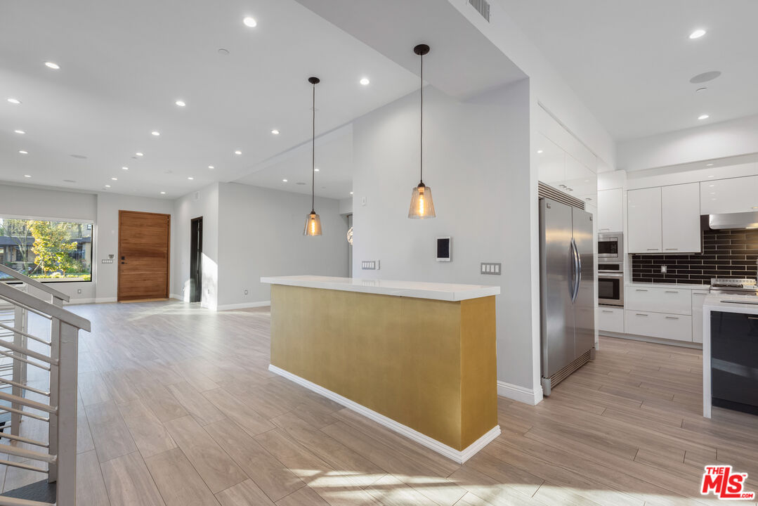 156 North Wetherly Drive Beverly Hills, CA 90211 - Photo 5 of 57 a view of a kitchen with a refrigerator a stove top oven a counter space and wooden floor