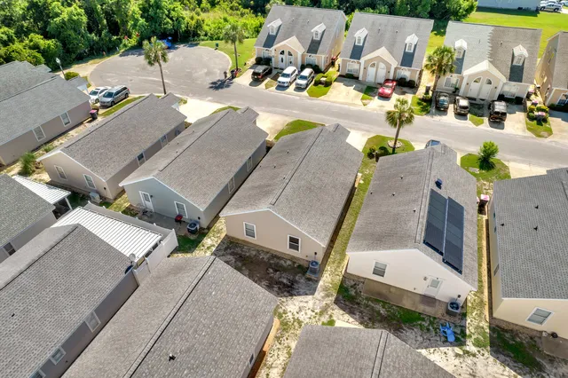 a view of a white house with a big yard and large tree