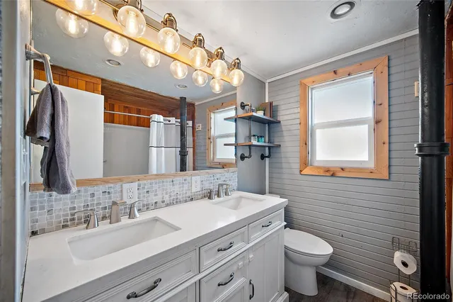 a bathroom with a double vanity sink toilet and a mirror