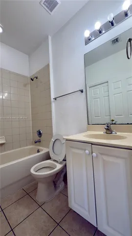 a bathroom with a sink a toilet a mirror a bathtub and shower