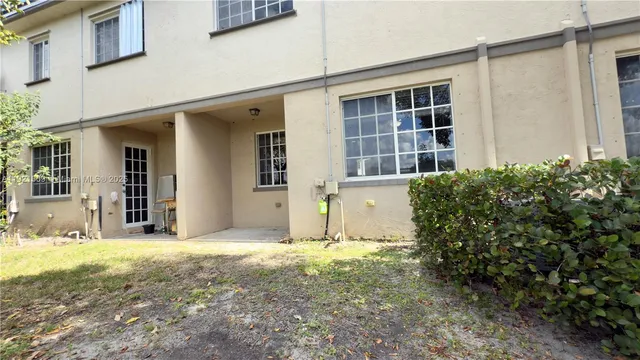 a view of a house with backyard and glass windows