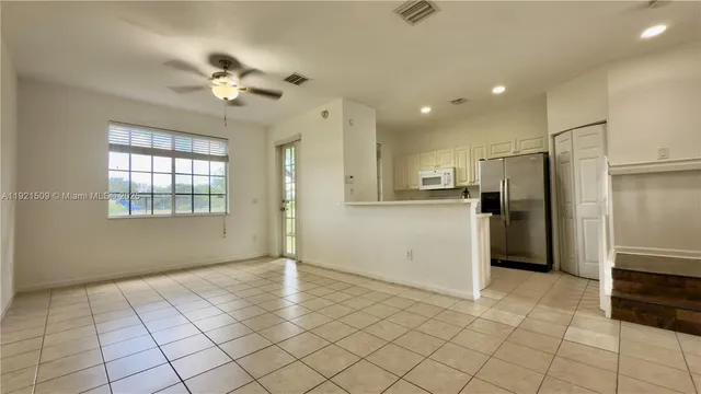 a view of a kitchen with a sink and an empty room