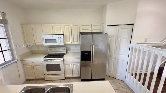 a kitchen with a refrigerator sink and stove