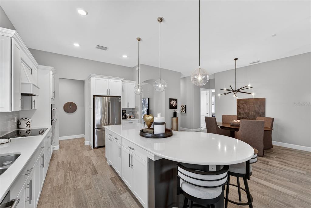1721 Hyssop Loop North Port, FL 34289 - Photo 12 of 70 a kitchen with sink a refrigerator and chairs