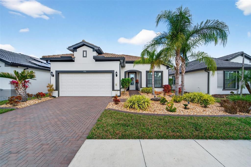 1721 Hyssop Loop North Port, FL 34289 - Photo 2 of 70 a front view of a house with a garden and patio