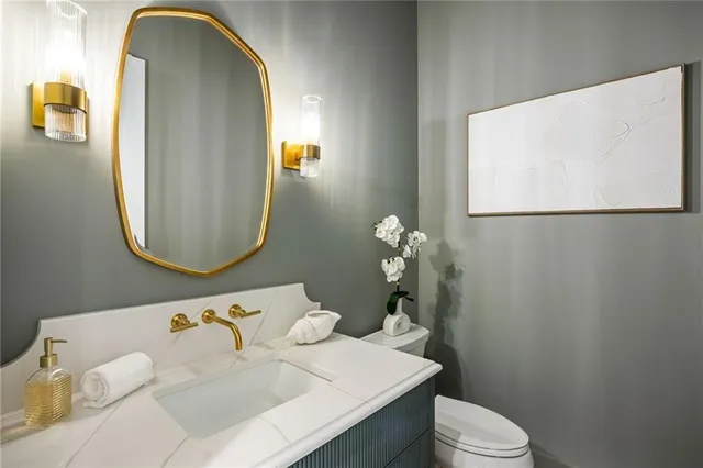 a bathroom with a sink mirror and toilet