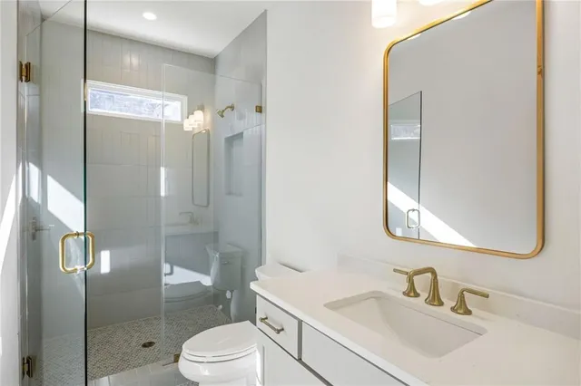 a bathroom with a sink a toilet and shower