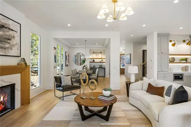 a living room with furniture a fireplace and a chandelier