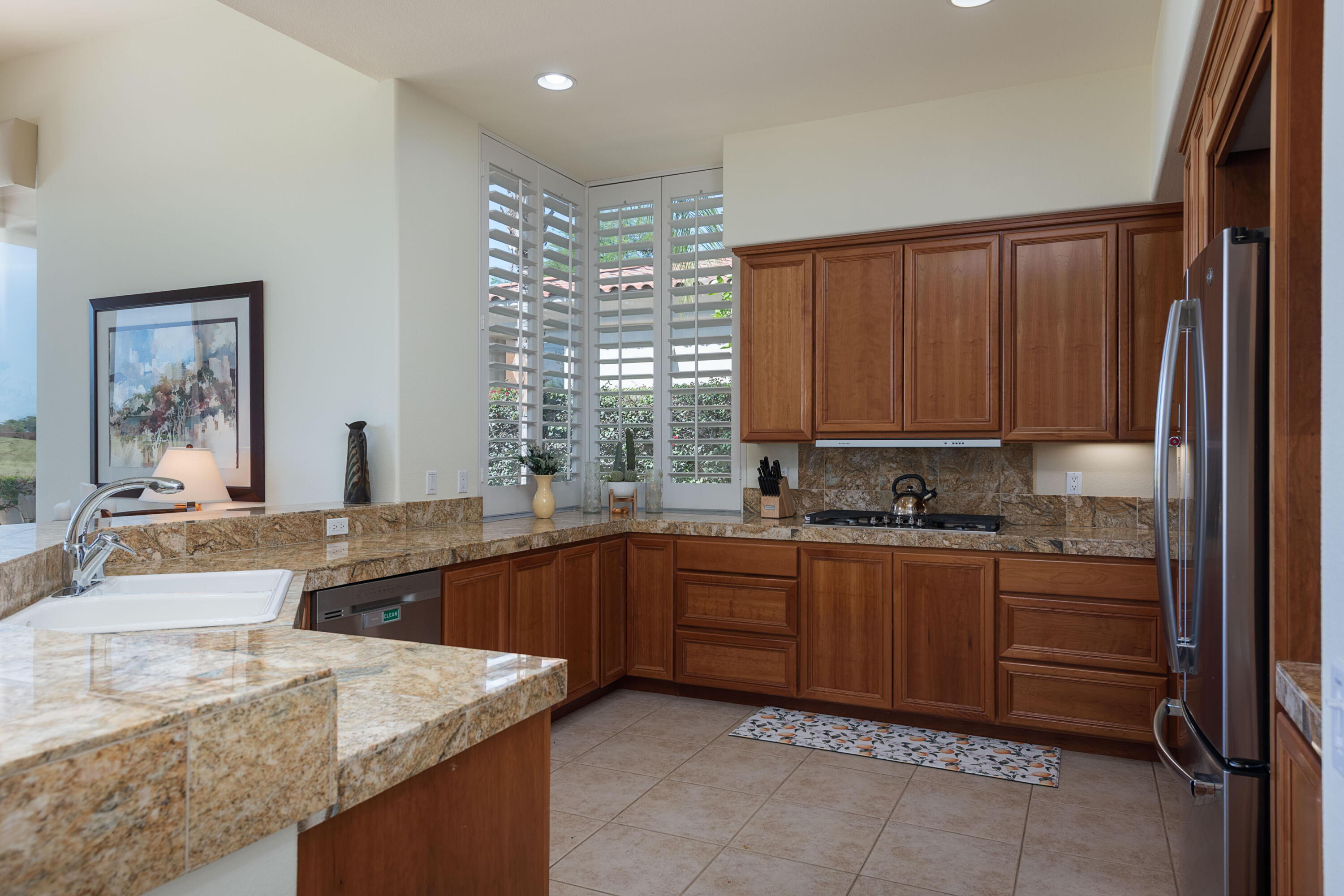 278 Loch Lomond Road Rancho Mirage, CA 92270 - Photo 23 of 49 a kitchen with stainless steel appliances granite countertop wooden cabinets a sink and dishwasher
