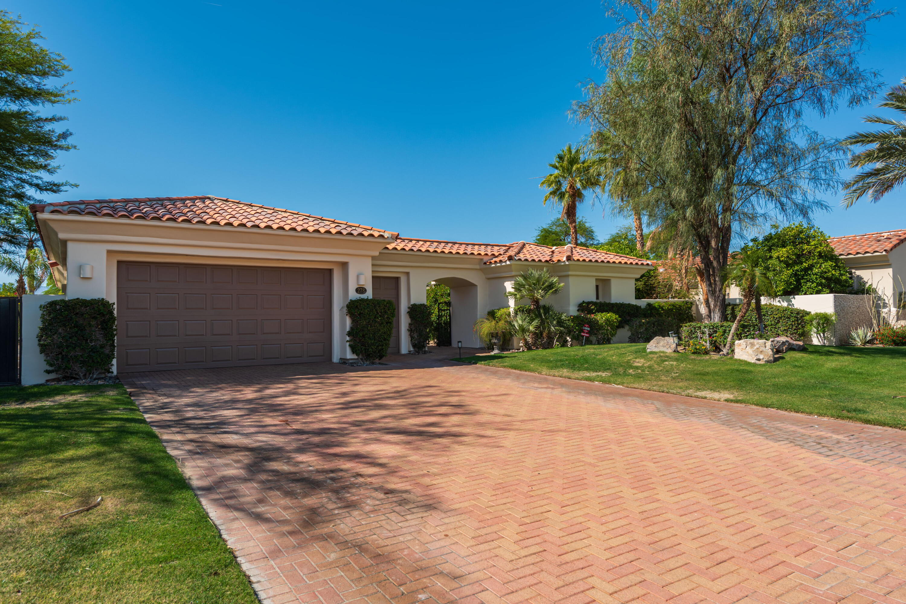 278 Loch Lomond Road Rancho Mirage, CA 92270 - Photo 4 of 49 a front view of a house with a yard and garage