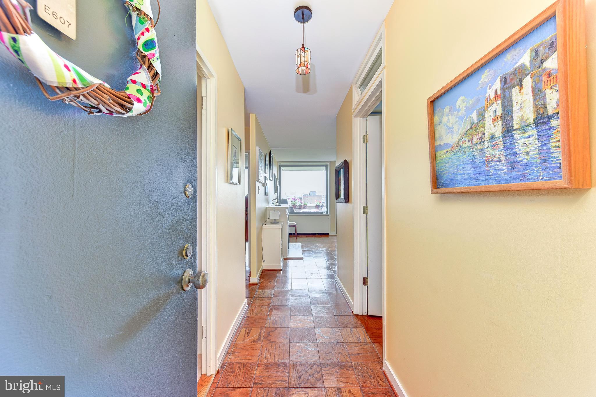 1245 4th Street Southwest, Unit E607 Washington, DC 20024 - Photo 5 of 24 a view of a hallway with a dining area with chandelier