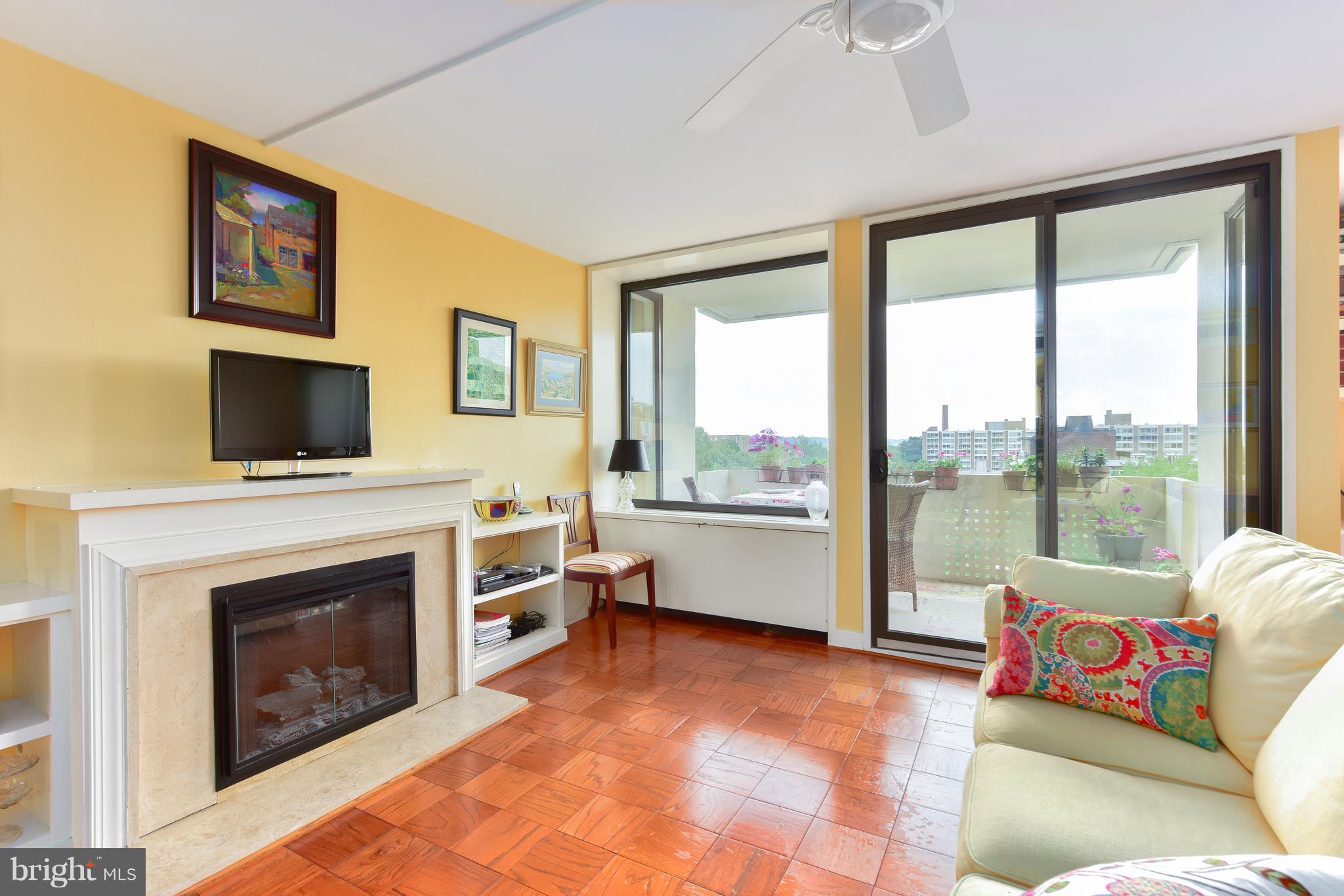1245 4th Street Southwest, Unit E607 Washington, DC 20024 - Photo 7 of 24 a living room with furniture a flat screen tv and a fireplace