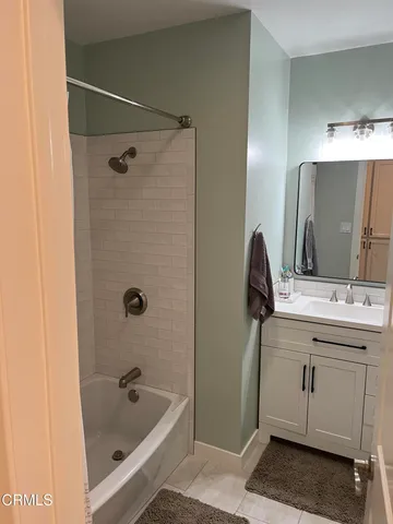 a bathroom with a tub sink and mirror