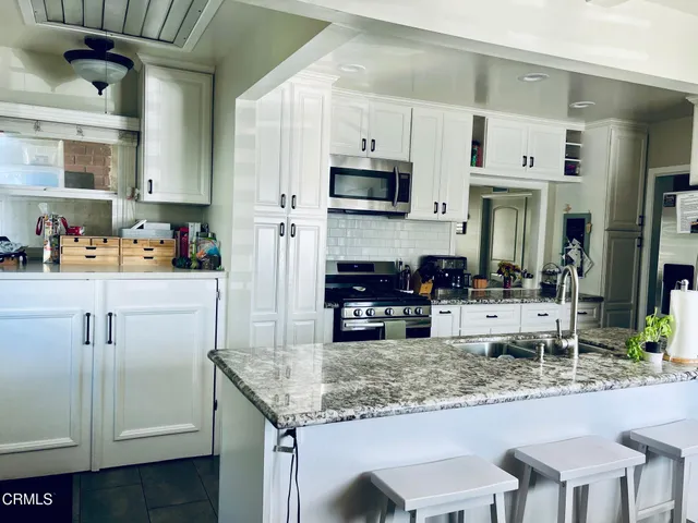 a kitchen with white cabinets and appliances