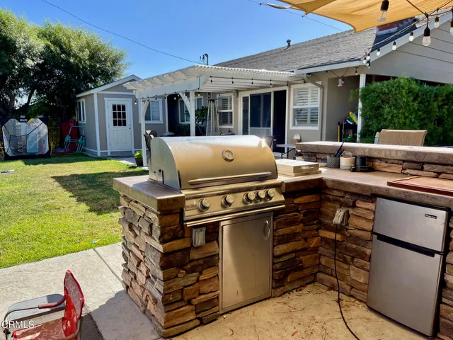 a view of a house with backyard stove and sitting area