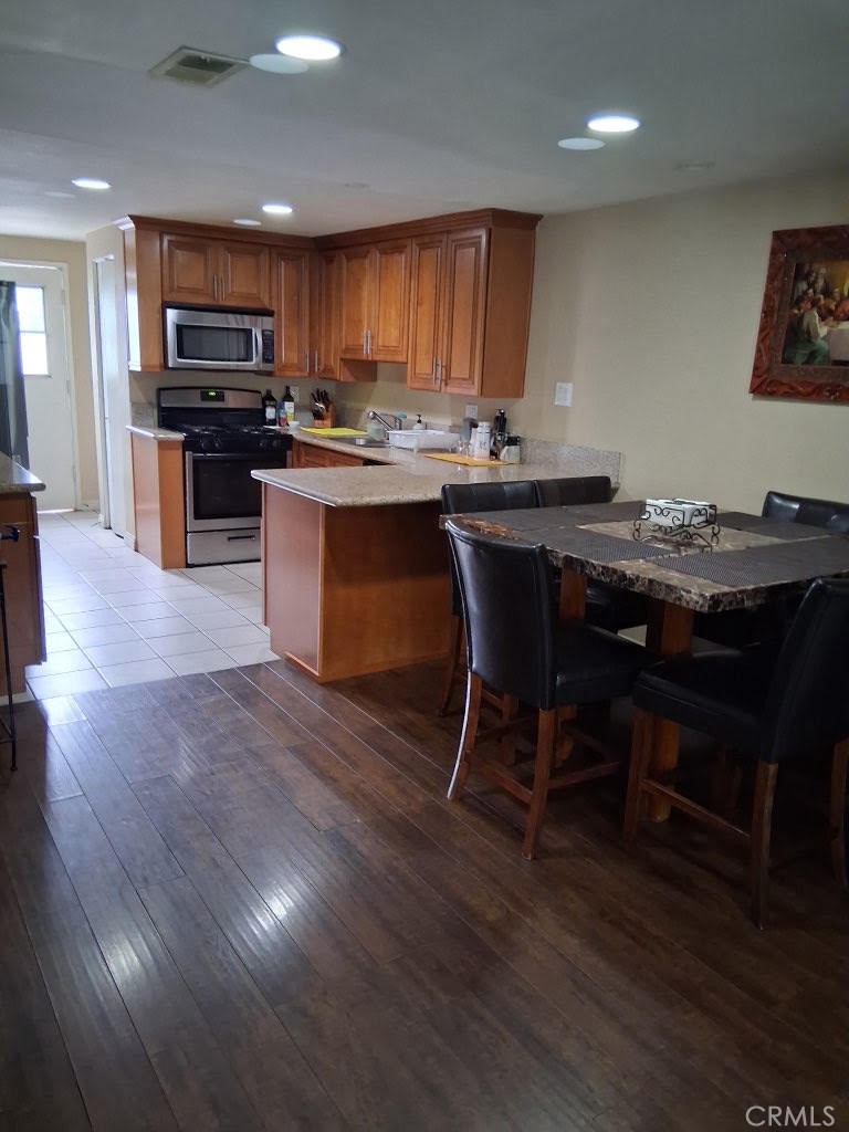 1777 Mitchell Avenue, Unit 29 Tustin, CA 92780 - Photo 15 of 26 a kitchen with stainless steel appliances wooden floors and wooden cabinets