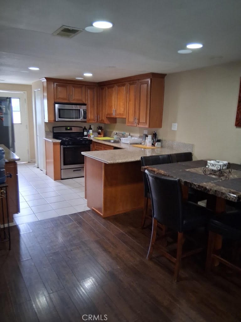1777 Mitchell Avenue, Unit 29 Tustin, CA 92780 - Photo 16 of 26 a kitchen with stainless steel appliances kitchen island granite countertop a stove a sink and a microwave