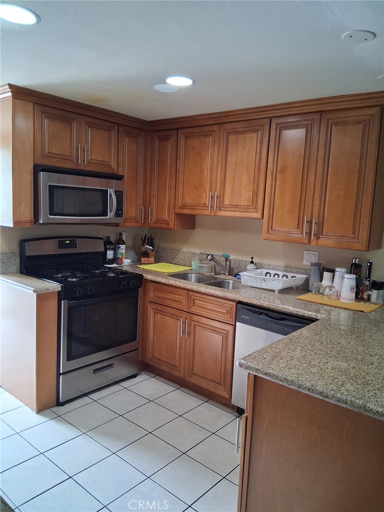 1777 Mitchell Avenue, Unit 29 Tustin, CA 92780 - Photo 17 of 26 a kitchen with granite countertop a stove top oven microwave and cabinets