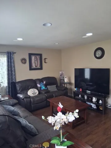 a living room with furniture potted plant and a flat screen tv