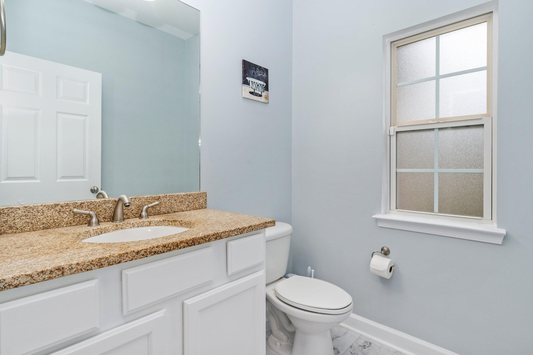 6082 Robin Road Crestview, FL 32539 - Photo 28 of 45 a bathroom with a granite countertop sink toilet and mirror