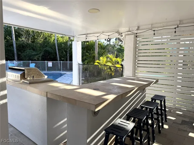 a view of balcony with wooden floor and palm trees