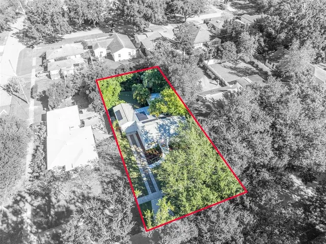 an aerial view of residential houses with outdoor space and trees