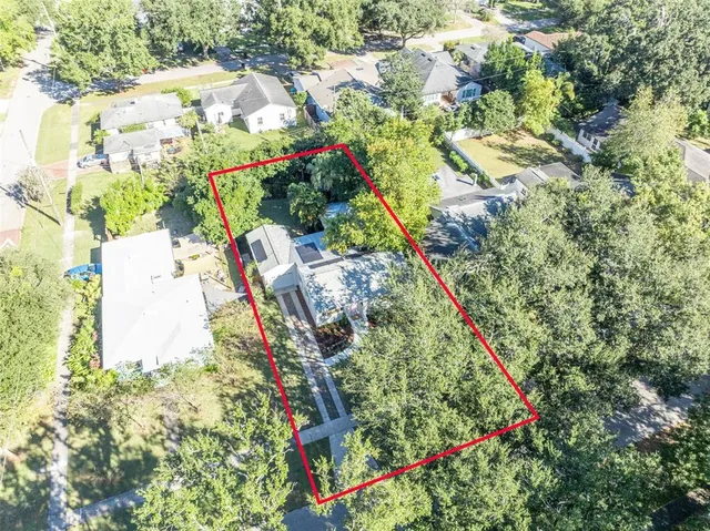 an aerial view of residential houses with outdoor space and trees
