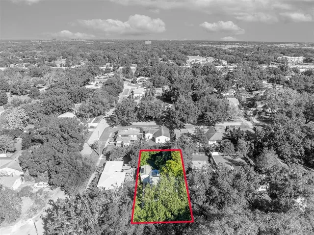 an aerial view of residential houses with outdoor space and trees
