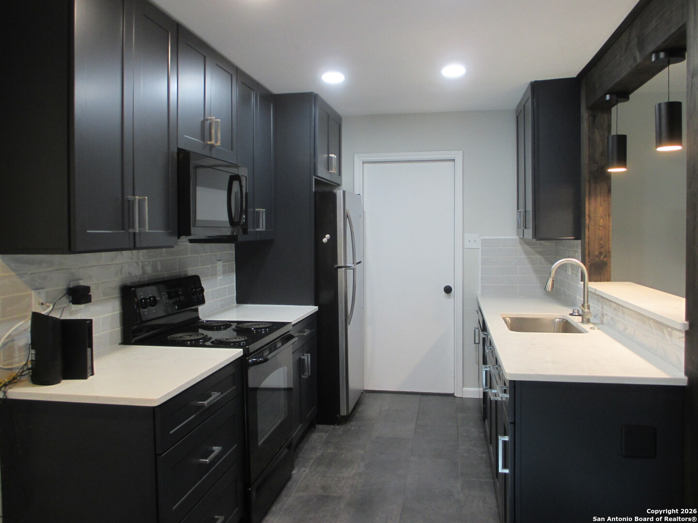 7126 Spring Flower Street San Antonio, TX 78249 - Photo 3 of 20 a kitchen that has a sink stainless steel appliances a counter space and cabinets